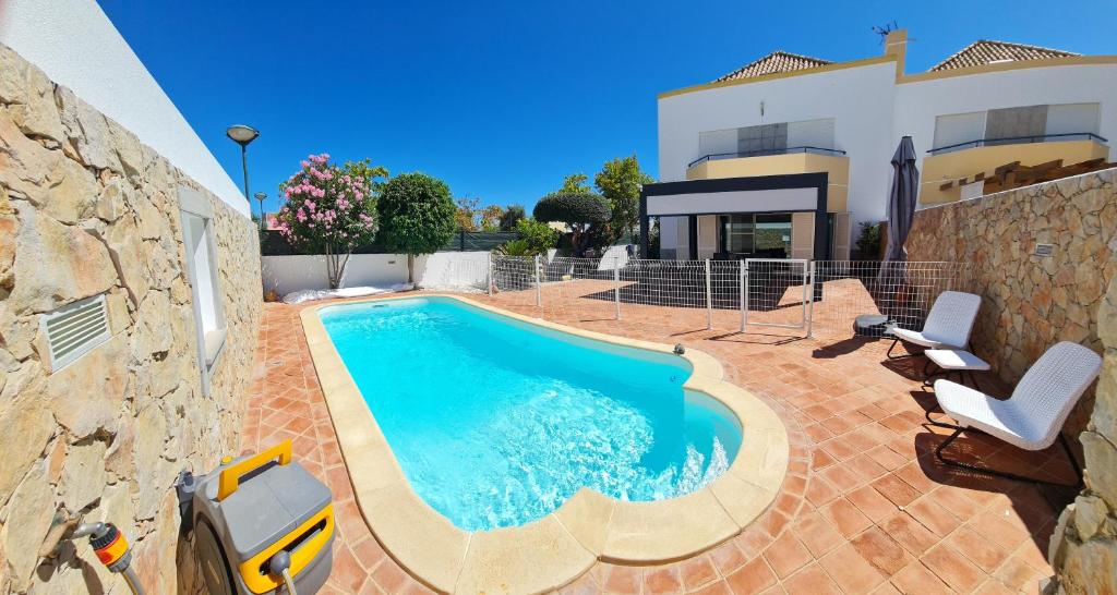a swimming pool in front of a house at VILLA DO LIMAO in Tavira