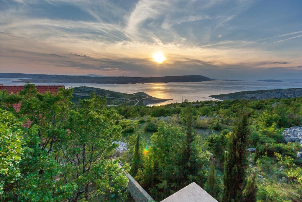 a sunset over a body of water with trees at Apartment Mikuš in Stinica