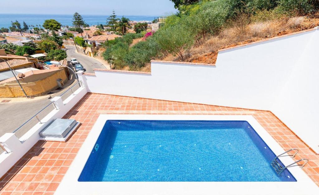 a swimming pool on the side of a house at Exlusivo Chalet Benagalbón in Málaga