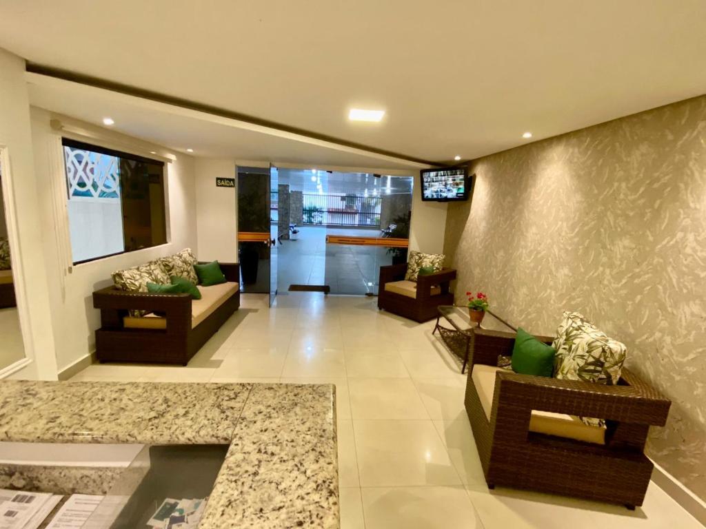 uma sala de estar com dois sofás e uma cozinha em APTO 14 - ENSEADA, PRÓXIMO REGIÃO DO PÃO DE AÇUCAR no Guarujá