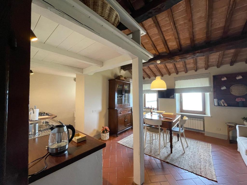 a kitchen and living room with a table and chairs at Appartamento centro storico La Pulcianella in Montepulciano
