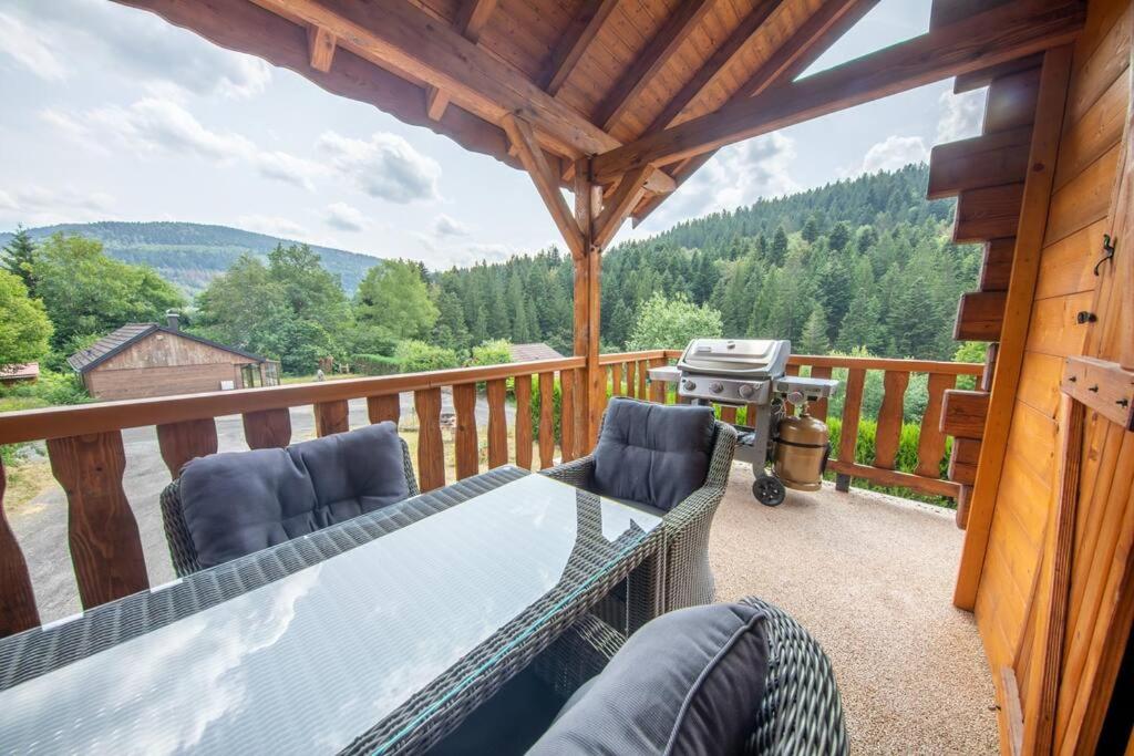 a patio with a table and chairs on a deck at F'amis Lodge, 10 à 20p et sauna in Cornimont