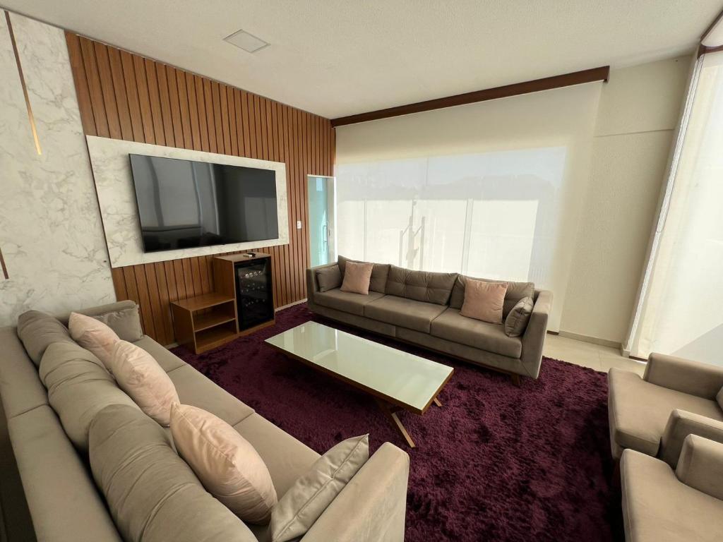 a living room with a couch and a tv at River X House in Manaus