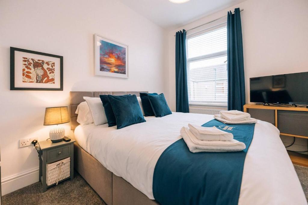 ein Schlafzimmer mit einem großen Bett mit blauen Kissen in der Unterkunft Hanson House in Redcar