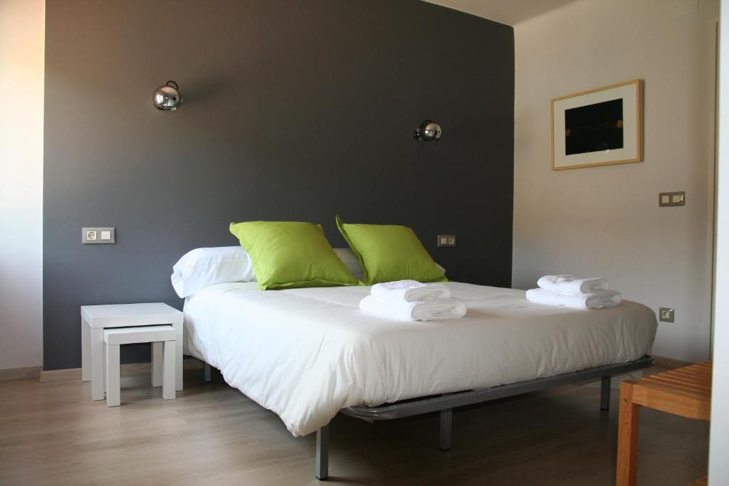 a bedroom with a large bed with green pillows at Hostal Totsompops in Colera