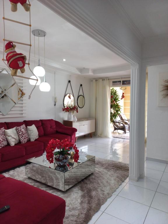 a living room with a red couch and a table at Casa de temporada Raio de sol in Piranhas