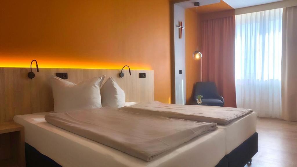 ein Schlafzimmer mit einem großen Bett in einem Zimmer in der Unterkunft Heinrich Pesch Hotel in Ludwigshafen am Rhein