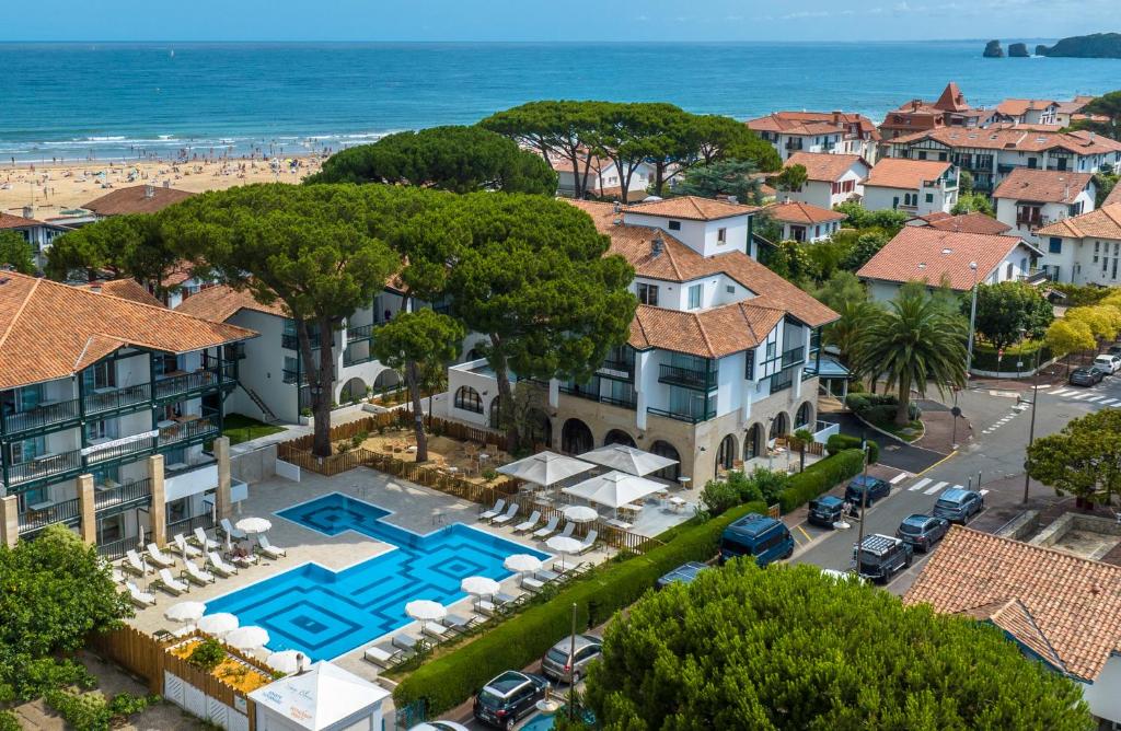 an aerial view of a house with a pool and the beach at Hôtel Ibaia in Hendaye