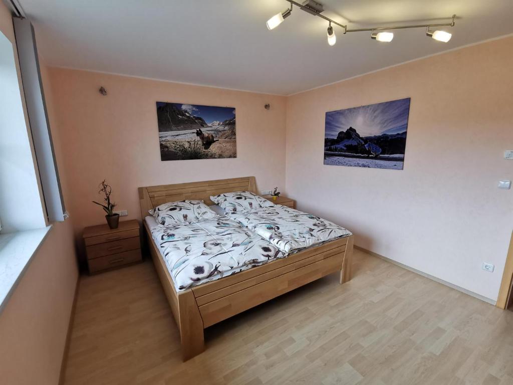 a bedroom with a bed and two pictures on the wall at Ferienwohnung Sonnenschein in Rieden am Forggensee