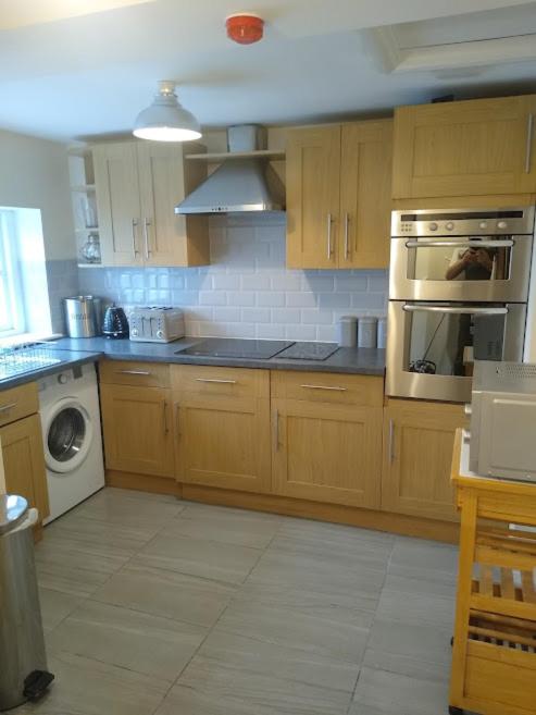 a kitchen with wooden cabinets and a stove top oven at 124A Castle Street Hinckley in Hinckley