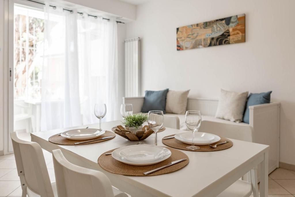 een witte eetkamer met een witte tafel en stoelen bij H11 [Bussana 2A] Mare in Bussana Nuova