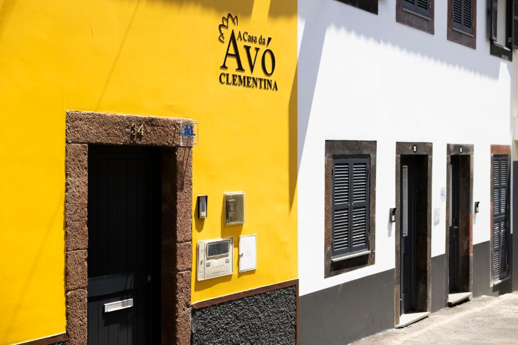 un bâtiment jaune et blanc avec un panneau sur lequel figure un panneau dans l'établissement Casa Da Avo Clementina, à Funchal