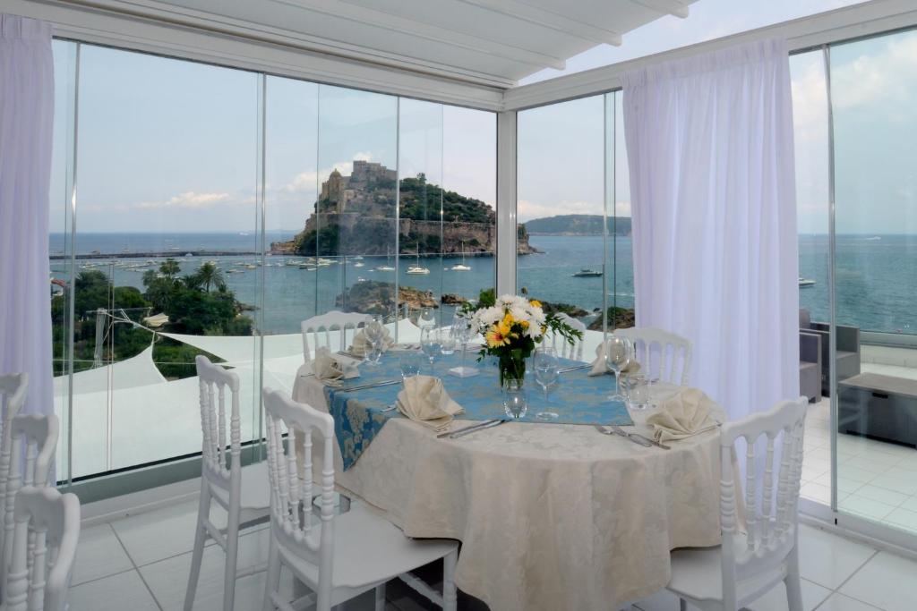 uma sala de jantar com uma mesa e vista para o oceano em Hotel La Ninfea em Ischia