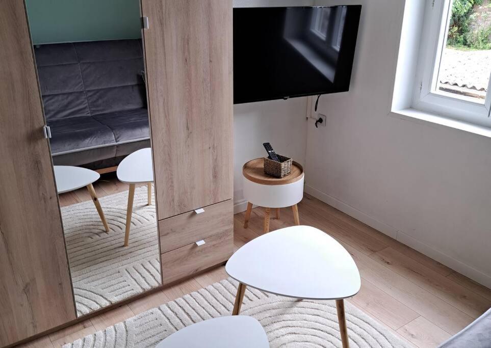 uma sala de estar com duas cadeiras brancas e uma televisão em Superbe T2 proche gare & centre em Amiens