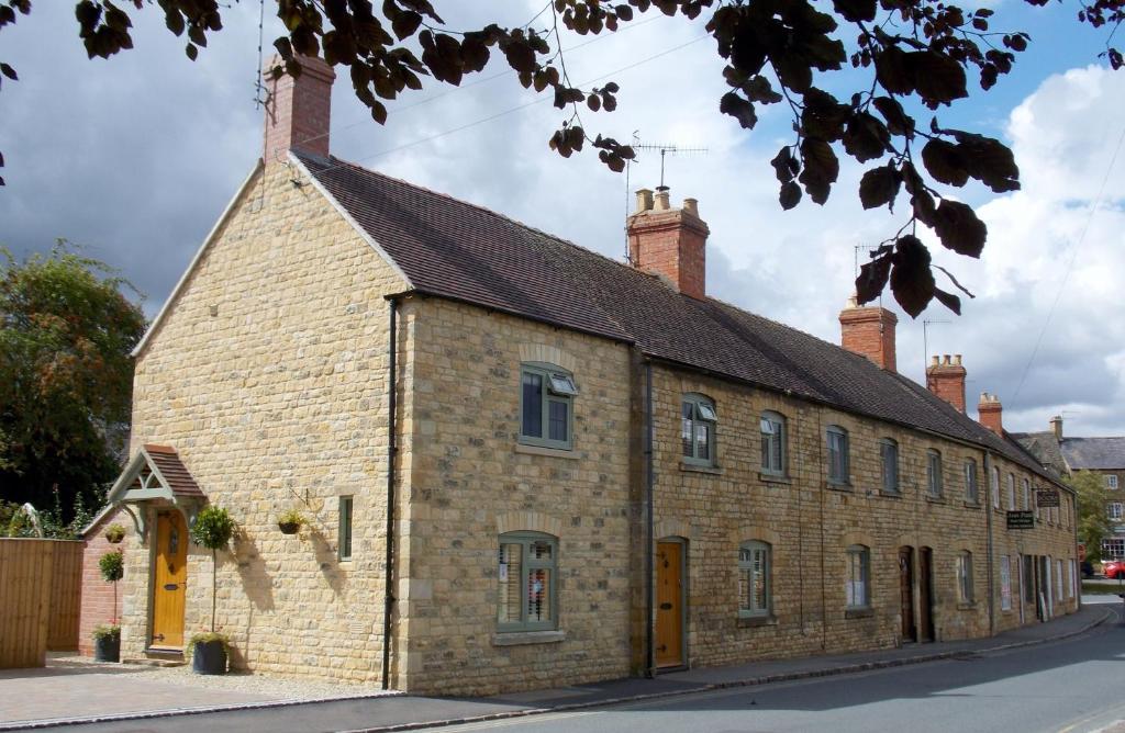 an old brick building with a black roof at Number Five Sheep Street in Chipping Campden