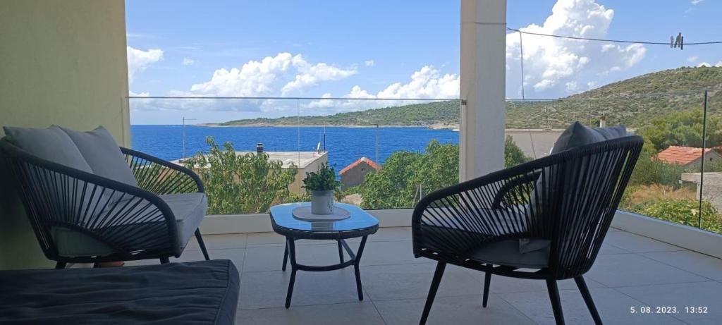 a patio with chairs and a table and a view of the ocean at Sunset Apartment in Sevid