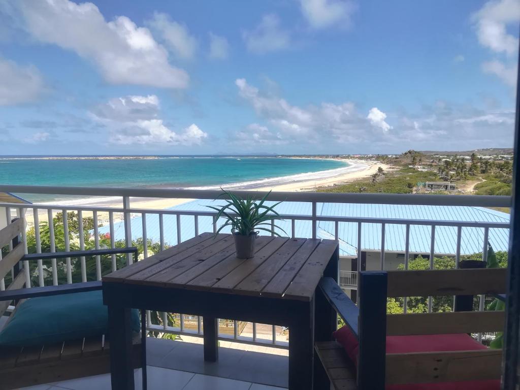 einen Balkon mit einem Tisch und Strandblick in der Unterkunft Happy Residence - Orient Beach 09 in Saint Martin