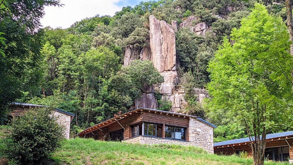 une maison sur une colline en face d'une montagne dans l'établissement Gite du Moulin, à Sainte-Marguerite-Lafigère