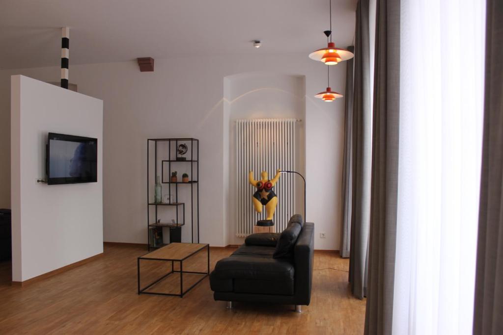 a living room with a black couch and a table at Moselloft Zeltingen-Rachtig in Zeltingen-Rachtig