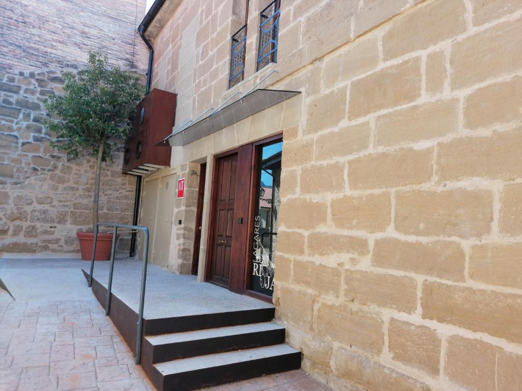 - un bâtiment en briques avec des escaliers menant à une porte dans l'établissement Lagares de Riooja-Briñas, à Briñas