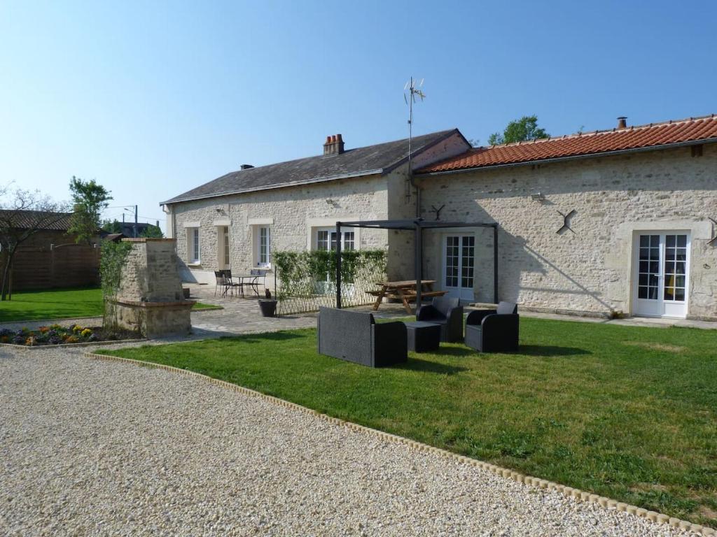 een stenen huis met een picknicktafel in de tuin bij Gîte 12 pers-5ch-6 lits doubles-jacuzzi-piscine chauffée in Arçay