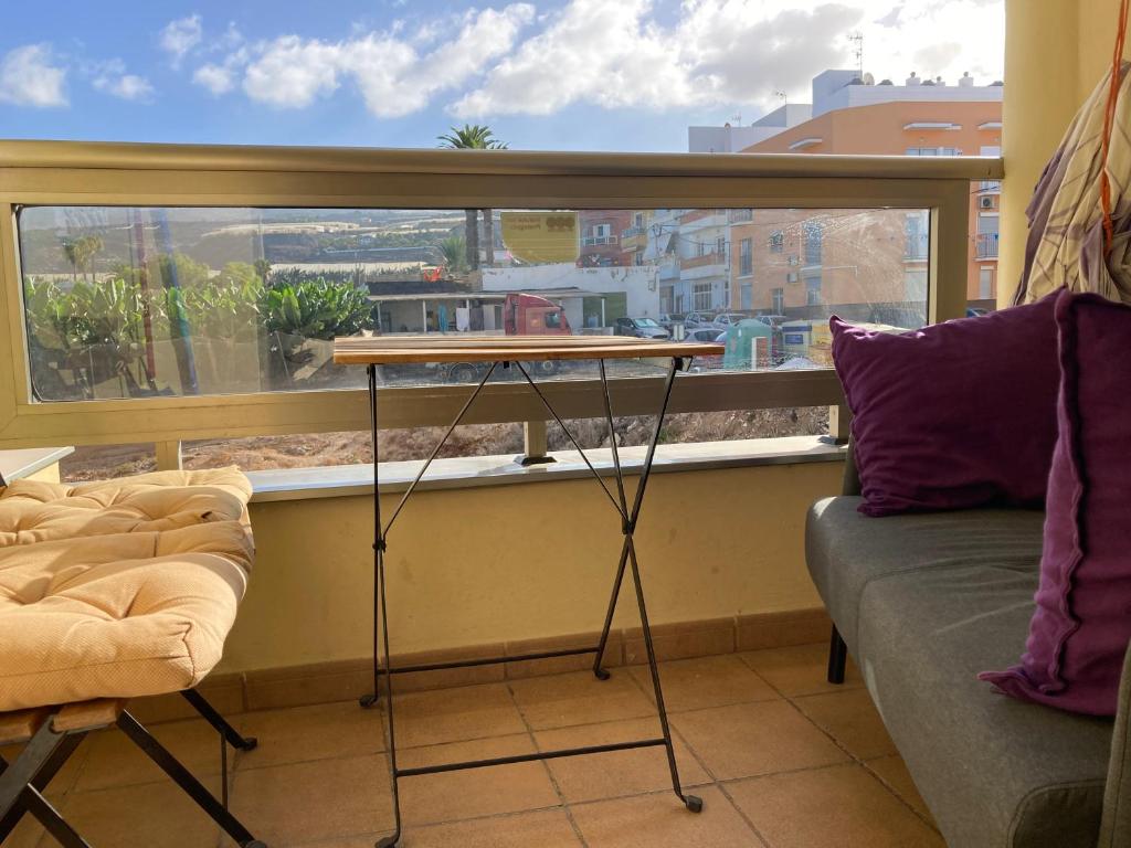 Cette chambre dispose d'une fenêtre avec une table et un canapé. dans l'établissement Remote work Family holiday apartment, à Alcalá