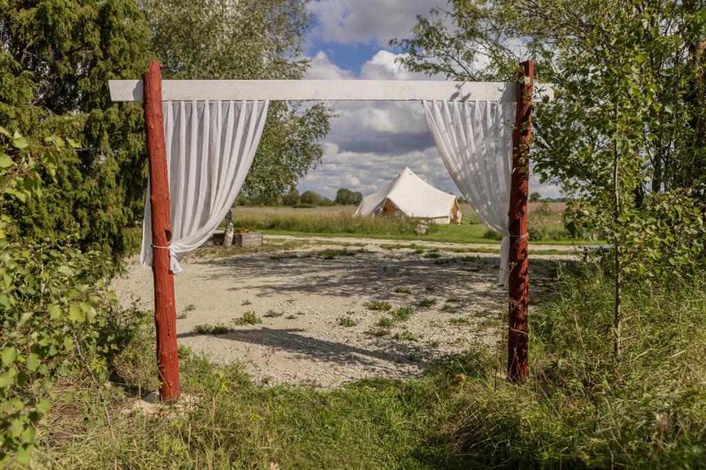 um portão aberto com uma cortina branca num campo em Niiduveere glämping em Viru-Nigula