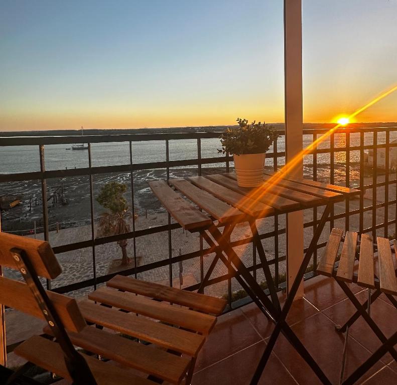 AYAMONTE SUNSET في ايامونتي: طاولة وكراسي على شرفة مع غروب الشمس