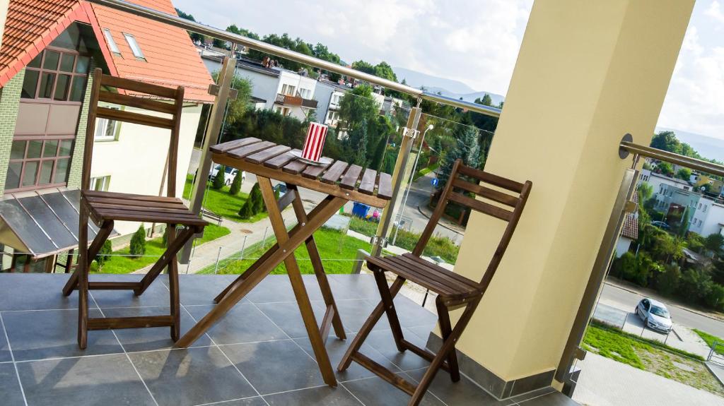 2 chaises sur un balcon avec drapeau américain dans l'établissement Apartament Widok Cieplice, à Jelenia Góra