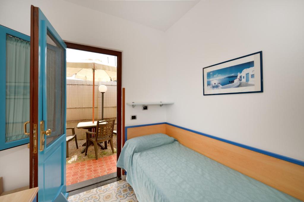 a bedroom with a bed and a balcony with a table at La Capannina in Procida