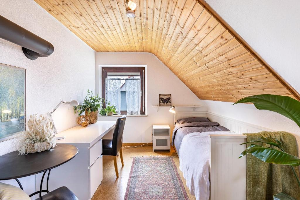 um quarto com uma cama, uma secretária e uma mesa em Ferienwohnung Kalkau em Lichtenstein