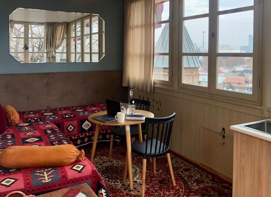 a room with a bed and a table with a laptop at Angels Roof - Betlemi. Garden & View over Old Tbilisi in Tbilisi City