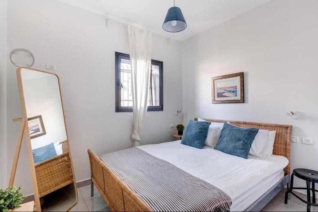 a bedroom with a bed with blue pillows and a mirror at One bedroom Machane Yehuda Design Apartment in Jerusalem