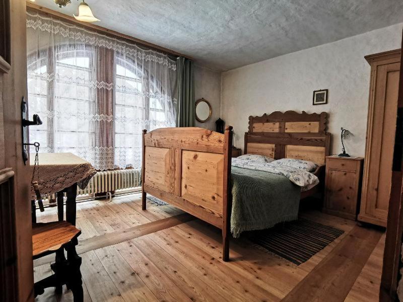 1 dormitorio con cama, mesa y ventana en Chasa de Capol - Historische Gaststätte & Weinkellerei en Sta Maria Val Müstair