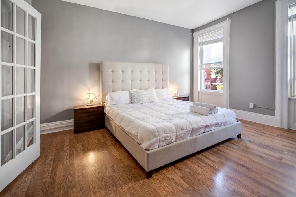 1 dormitorio blanco con 1 cama grande y 2 ventanas en Get Spoiled in this Urban 1BR 15min to NYC, en Hoboken