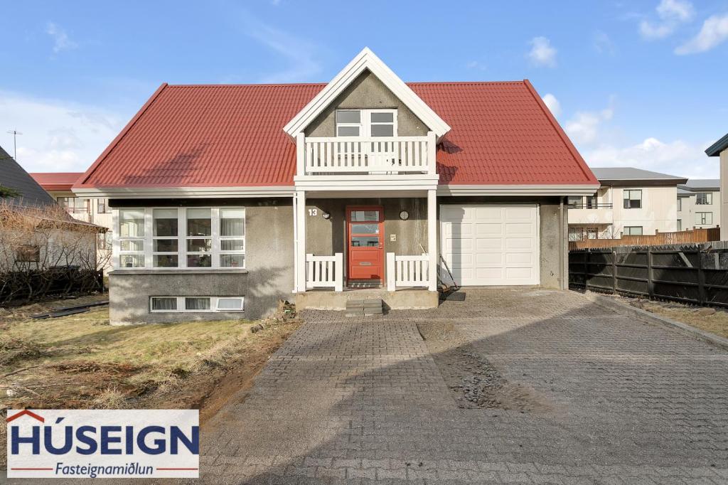 a house with a red roof and a driveway at Large apartment close to the centre in Reykjavík