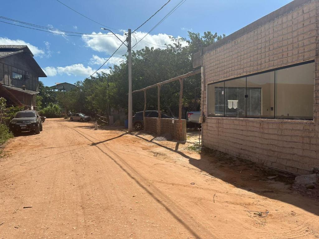 an empty dirt road next to a brick building at Sunsand Beach Suítes e Hostel in Camocim