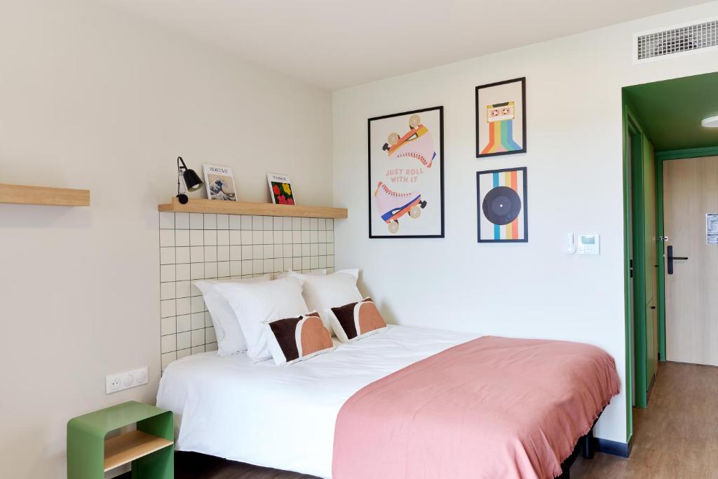 拉貝格的住宿－Hife Toulouse Labège，卧室配有带粉红色床单的大型白色床