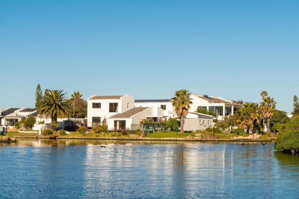 um grupo de casas ao lado de uma massa de água em Vlei Cove na Cidade do Cabo