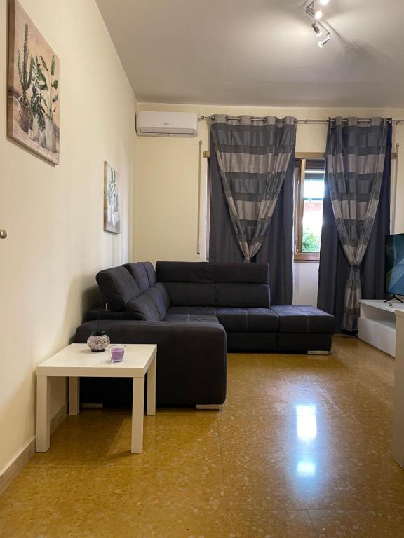 ein Wohnzimmer mit einem Sofa und einem Tisch in der Unterkunft La casa di ELE in Rom