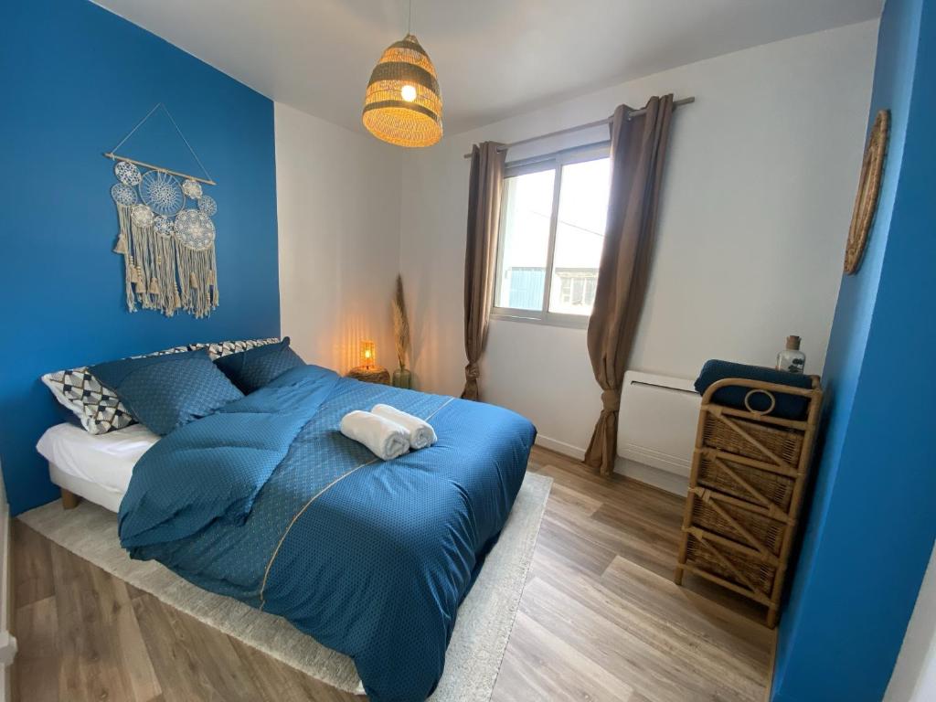 niebieska sypialnia z łóżkiem i oknem w obiekcie Wood & Sea I Cœur de breton. w mieście Crozon