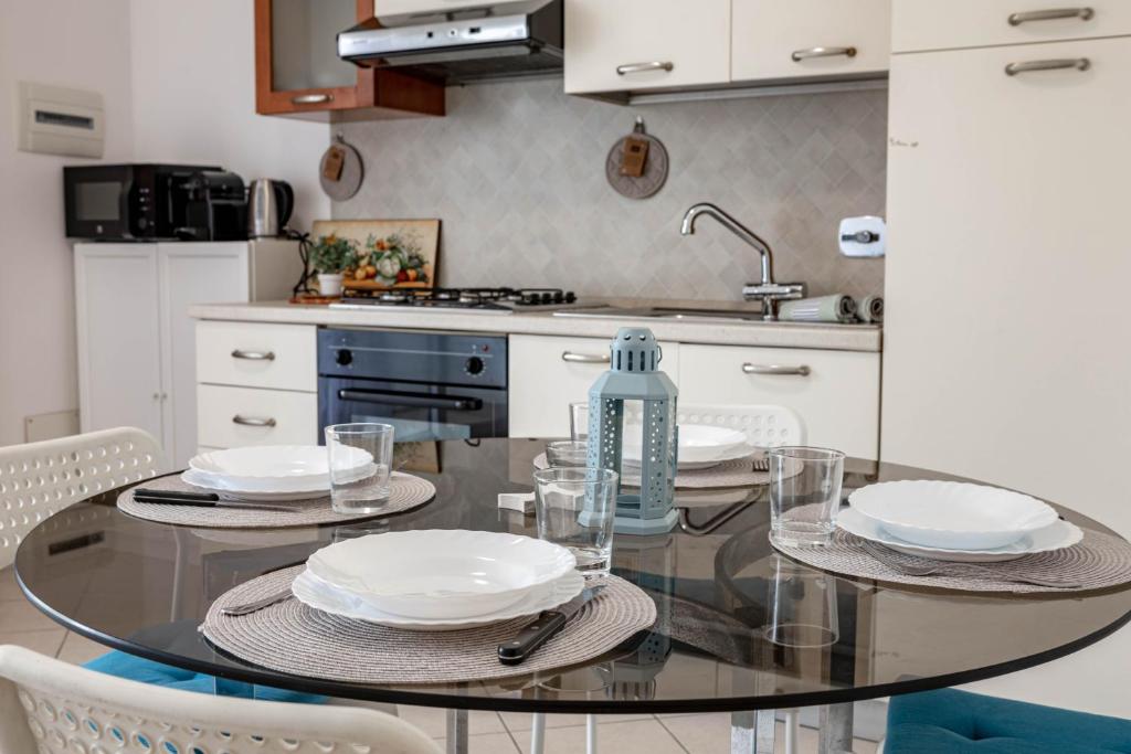 a kitchen with a glass table with dishes on it at H11 [Bussana 1A] Mare in Bussana Nuova