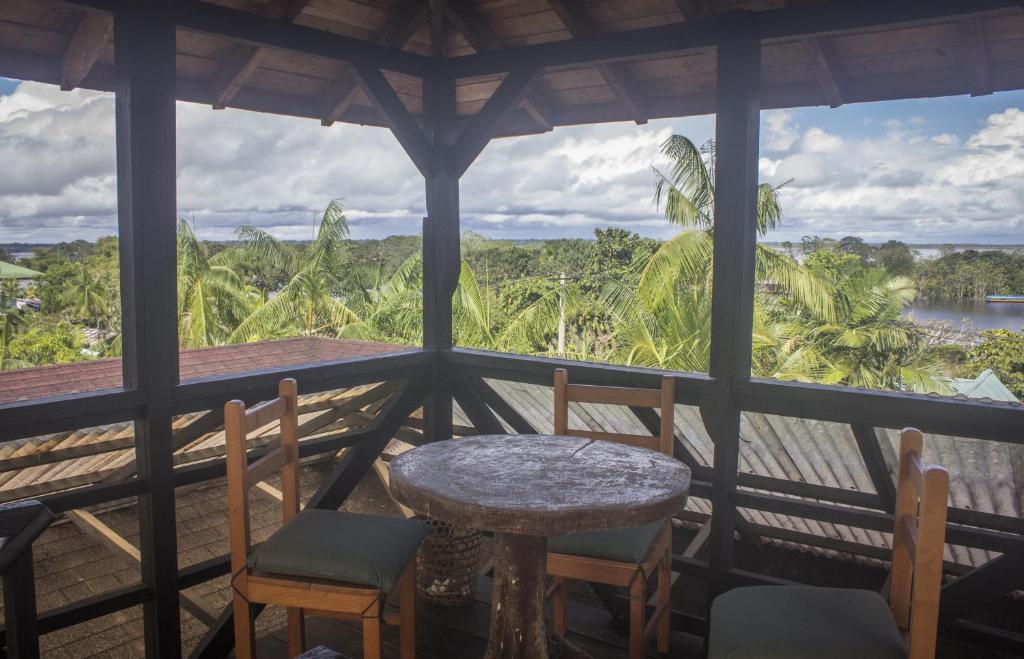 a table and chairs on a porch with a view at Waira Selva Hotel in Puerto Nari&ntilde;o