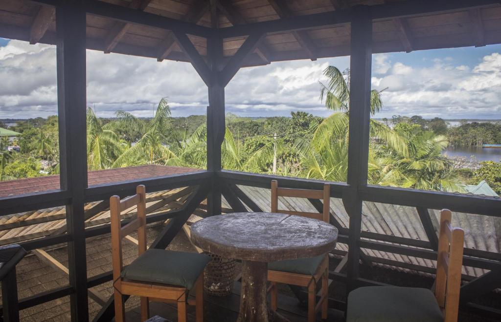 una mesa y sillas en un porche con vistas en Waira Selva Hotel, en Puerto Nariño