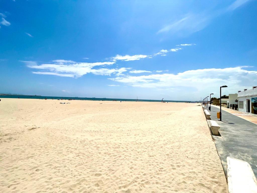 vista para uma praia arenosa num dia ensolarado em Precioso Apartamento de vacaciones playa Valencia Pinedo 2024 em Valência