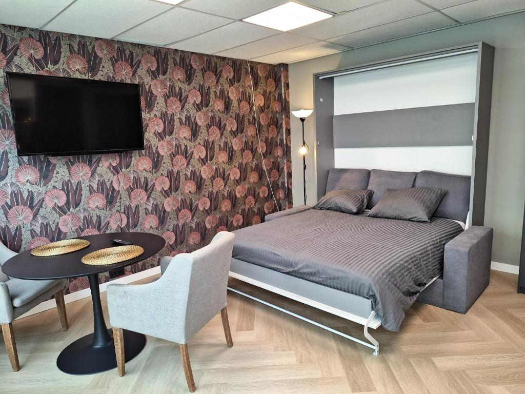 Mooie studio 14 Cn in center في روتردام: غرفة نوم بسرير وطاولة وتلفزيون