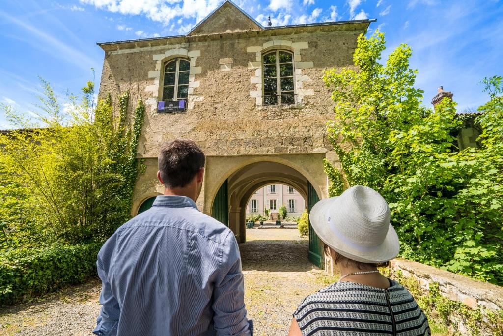 a man and a woman walking into a building at Château de la Tourlandry in Chemillé