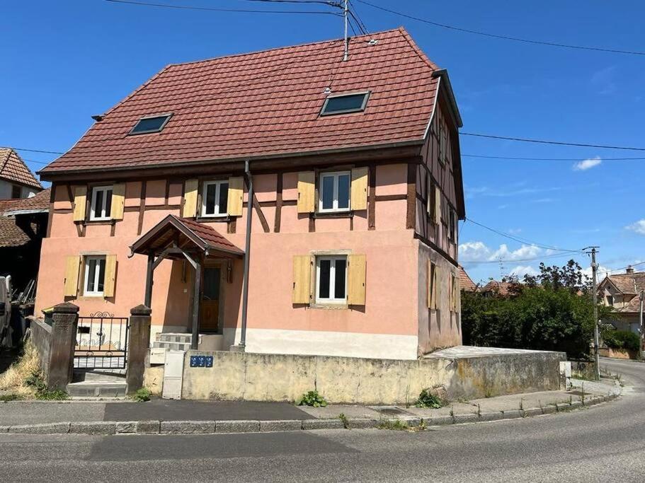 une maison avec un toit rouge dans une rue dans l'établissement La Maison Alsacienne, à Morschwiller-le-Bas