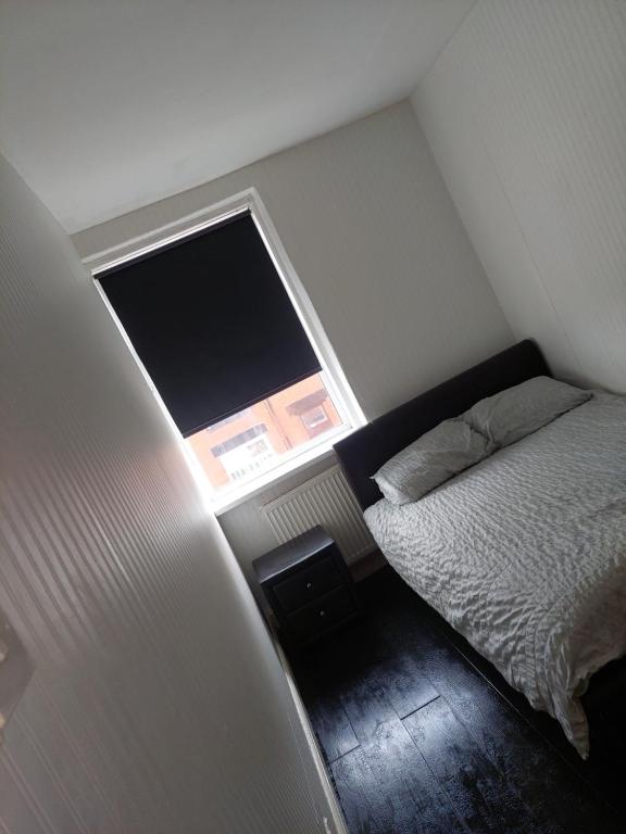 a small bedroom with a bed and a window at Double room in Lees