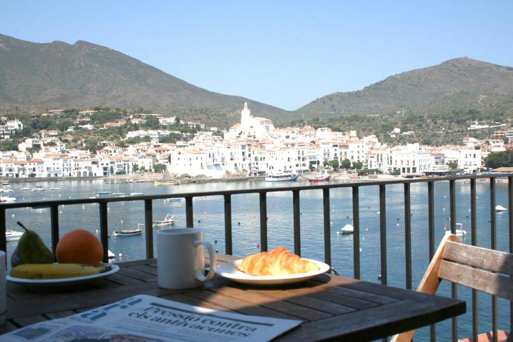 a table with a plate of food on a balcony at Pianc in Cadaqués
